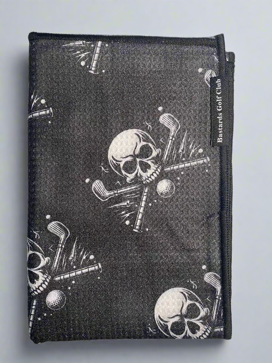 Black golf towel with skull and crossbones design and 'Bastards Golf Club' branding.