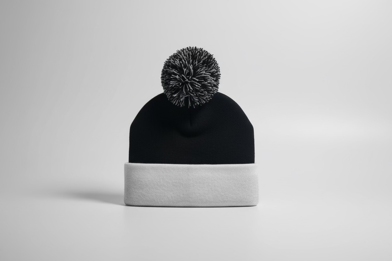Two-tone beanie with a pom-pom on a light gray background
