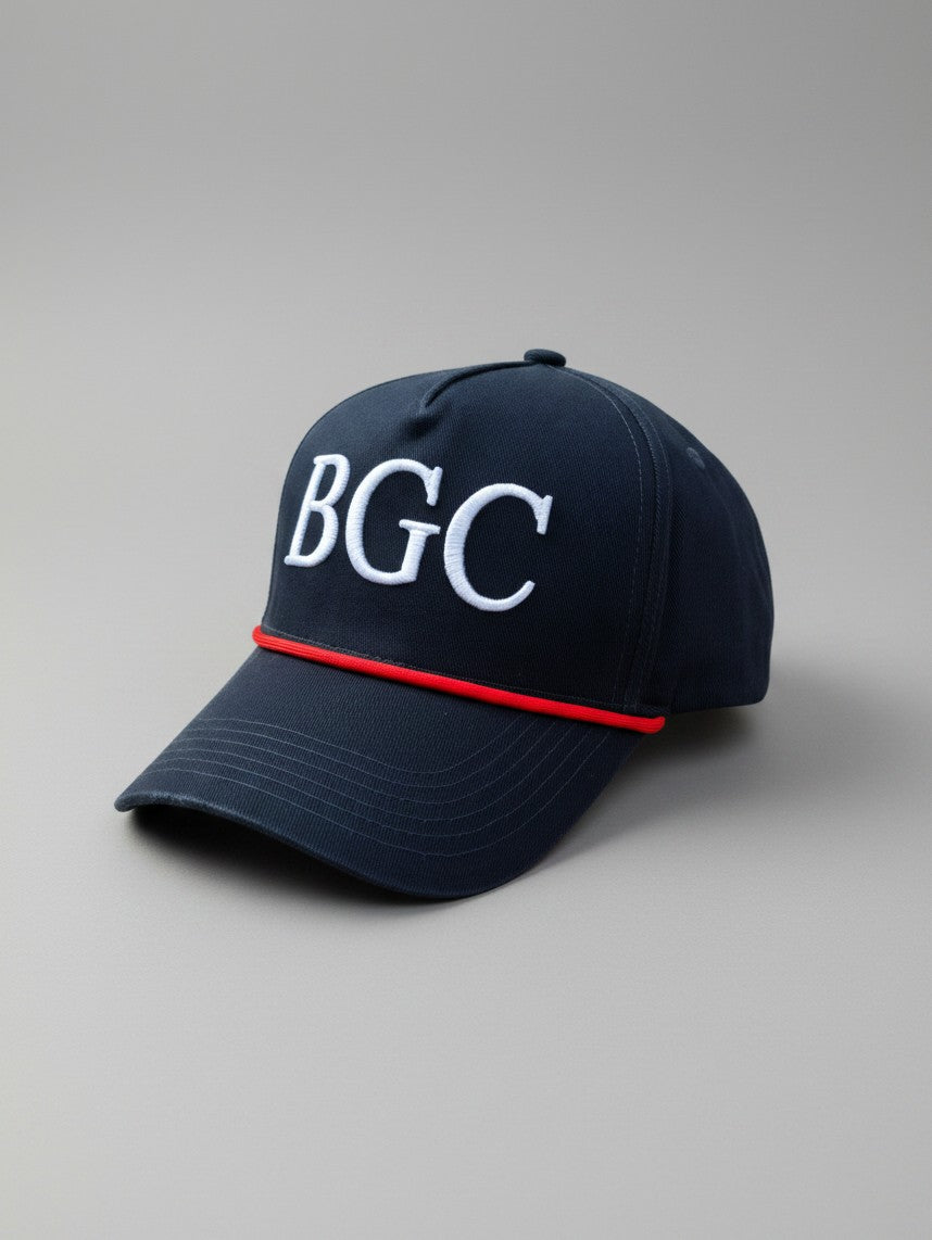 Three-quarter front view of The Yank navy golf cap showing white BGC embroidery and red braided rope